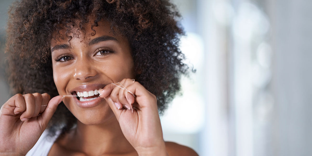 Woman flossing her teeth